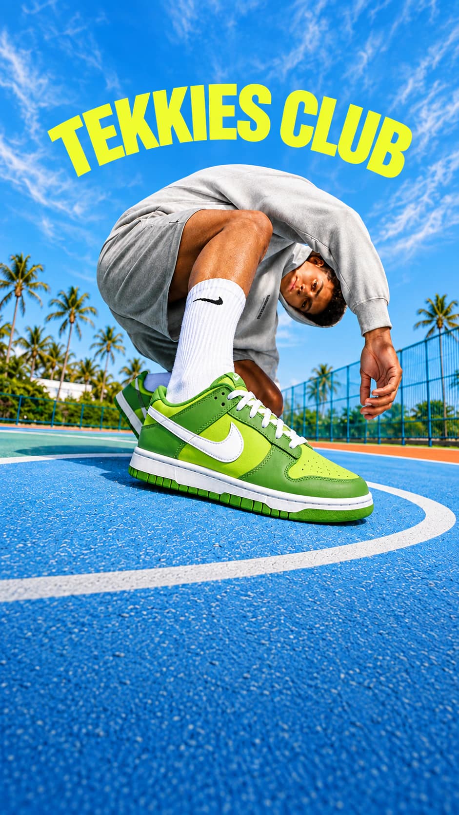 Model v šedé mikině, šedých kraťasech a zelených Nike teniskách pod nápisem Tekkies Club